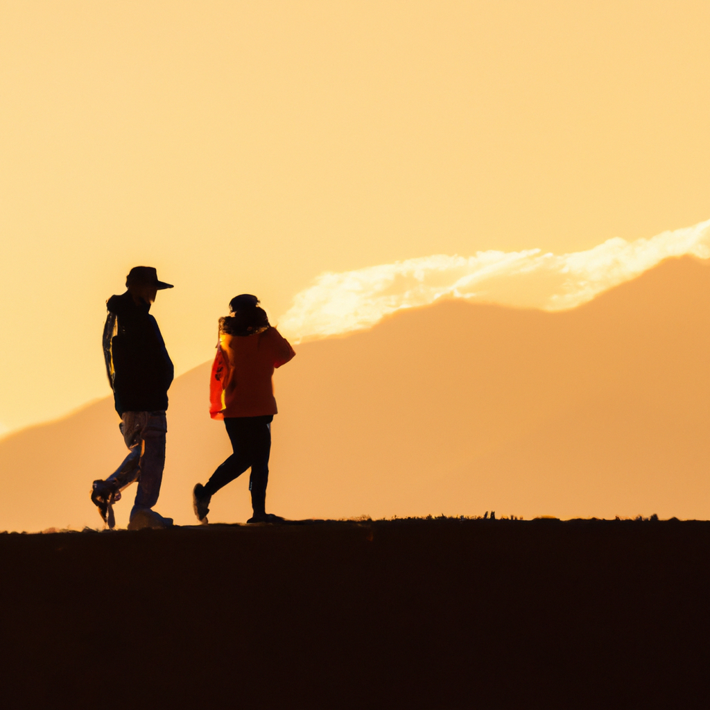 Pareja caminando en silueta con Andes al atardecer